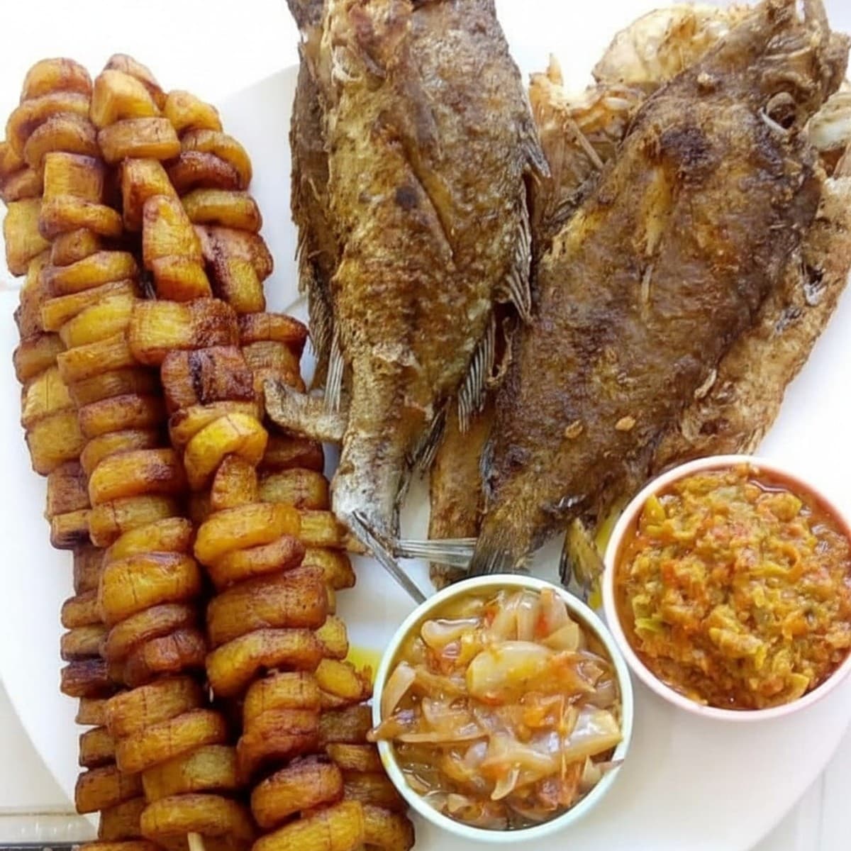 Brochettes de bananes plantain frit (Alloco) poissons sosso sole frit pâtes d’accompagnement à la moutarde