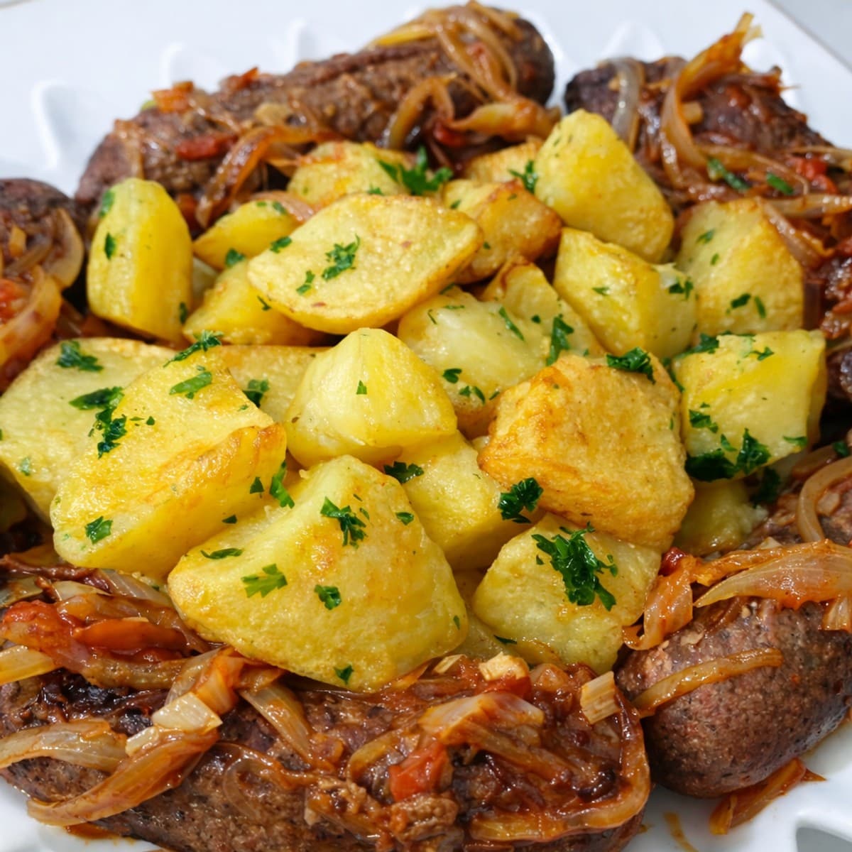 Pommes de terre sautées entourées de saucisses poêlées.