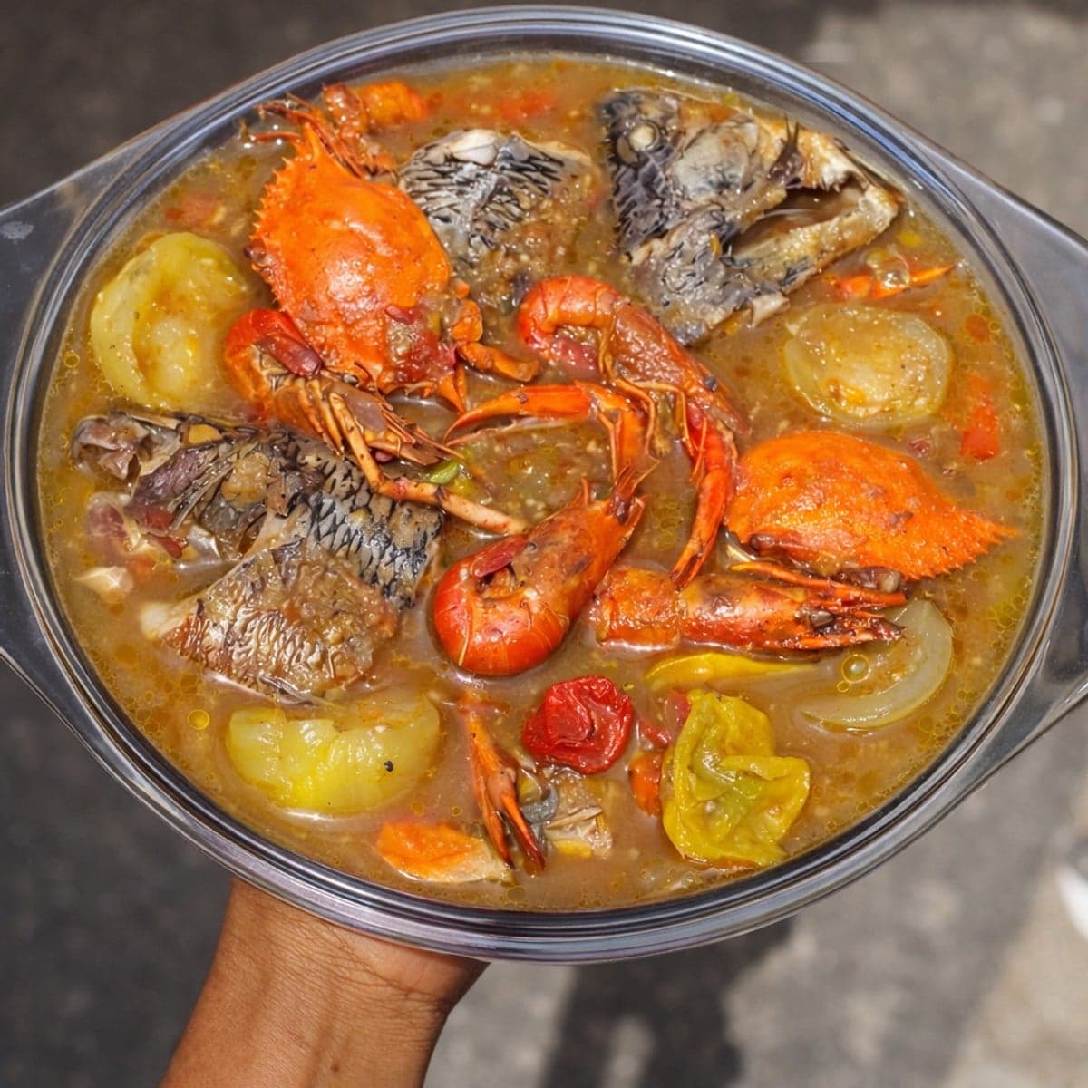 Un bouillon de poisson tilapia, crabes et crevettes bien piquant