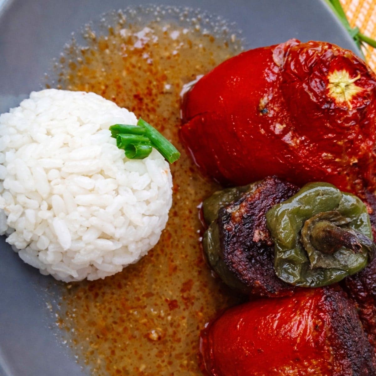 Tomate et poivron farcis baignant dans une sauce