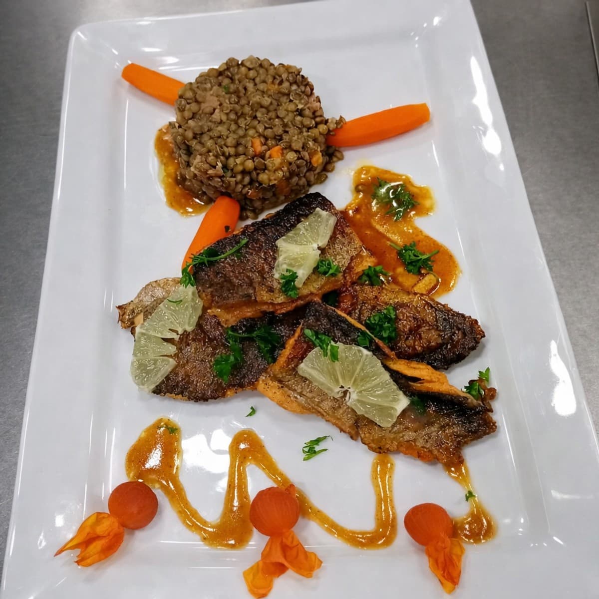 Filets de poisson truite accompagnés de lentilles vertes du Berry et des carottes glacées