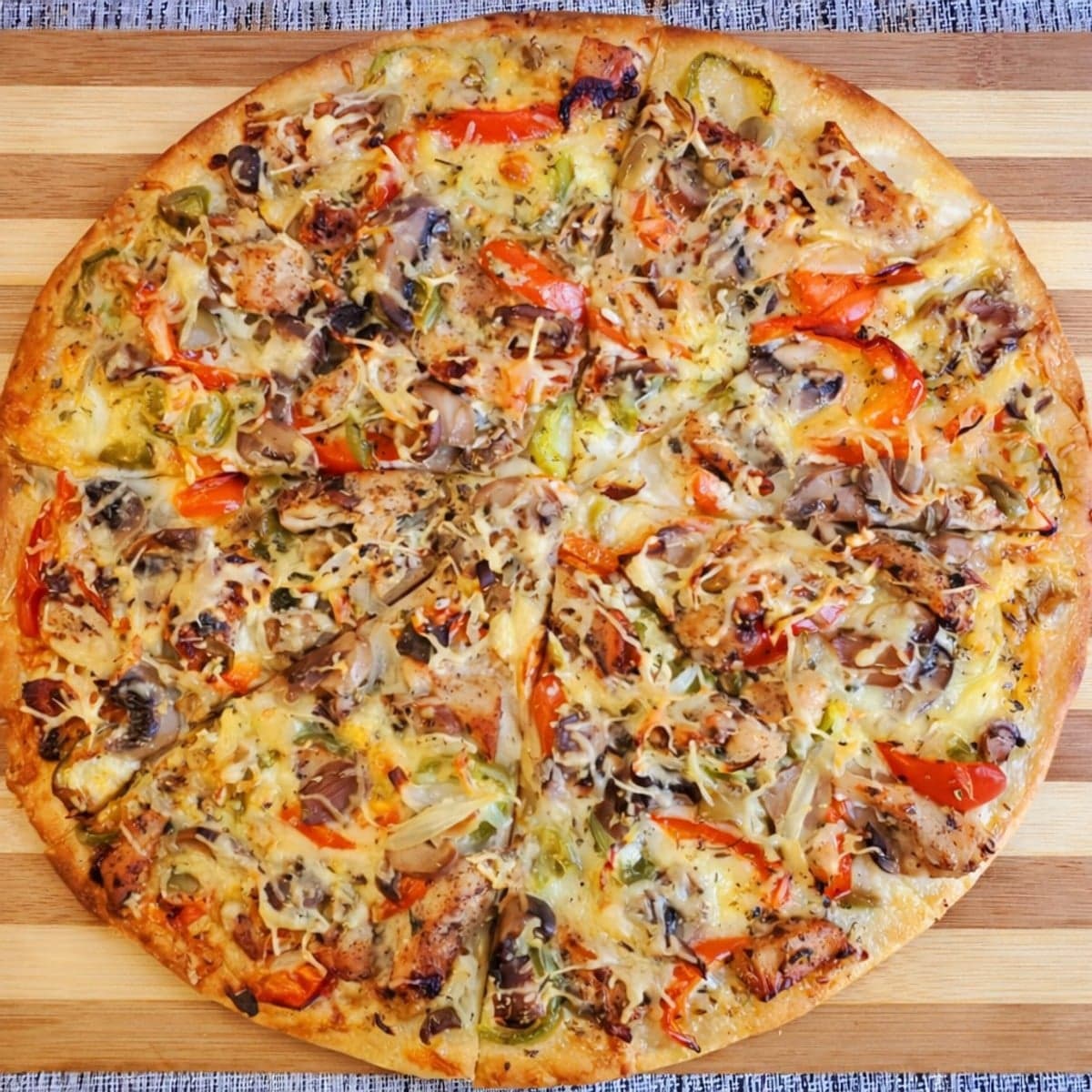 Pizza poulet aux épices africaines champignons crème fraiche poivrons