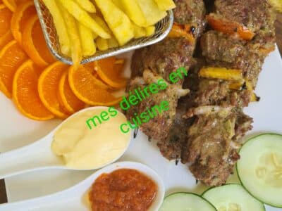 Brochettes de bœuf accompagné de salade et frites.