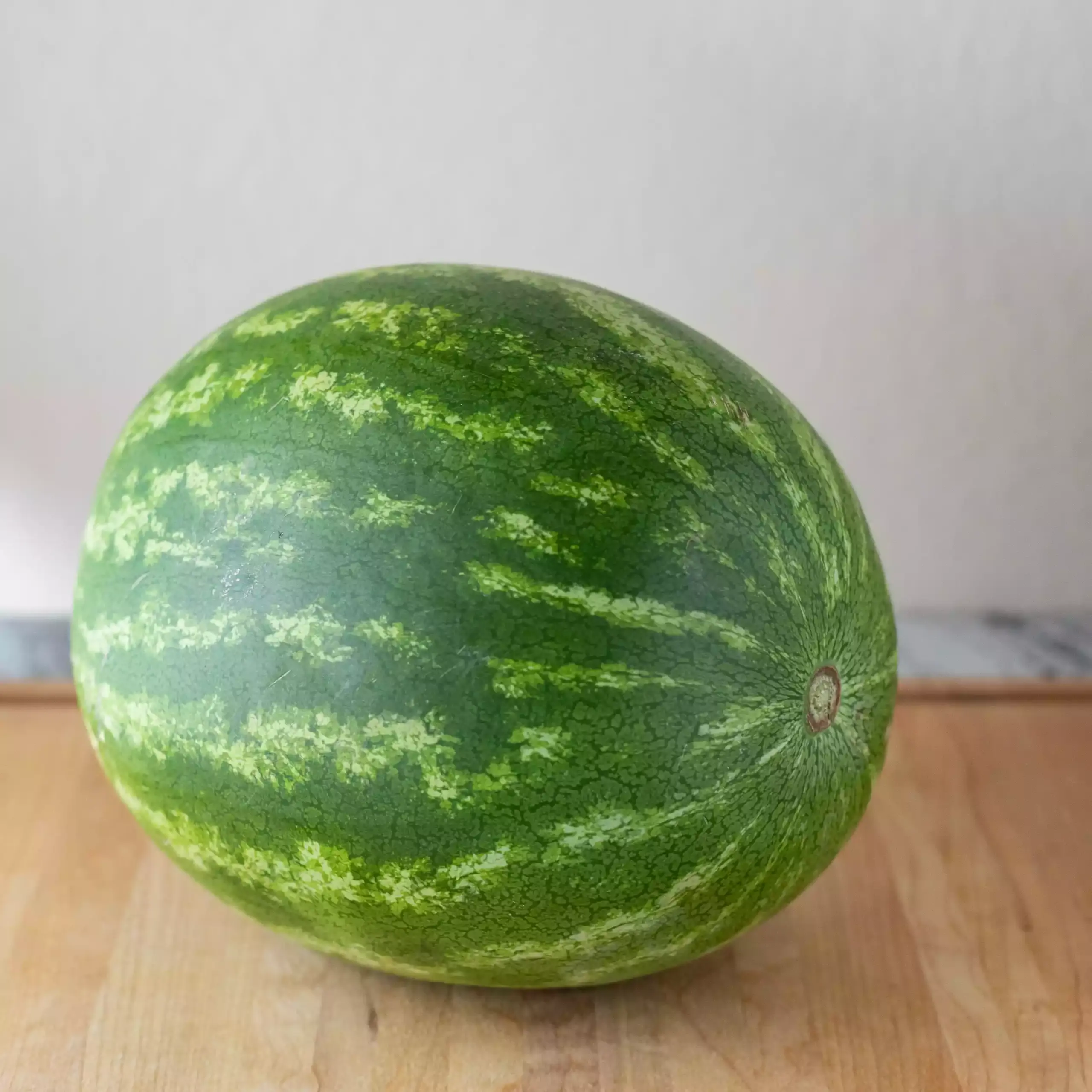Pastèque oblongue sur une planche à découper en bois