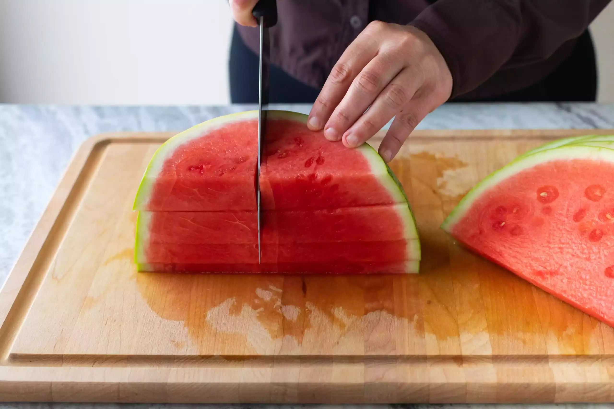 Couper les tranches de pastèque en quartiers