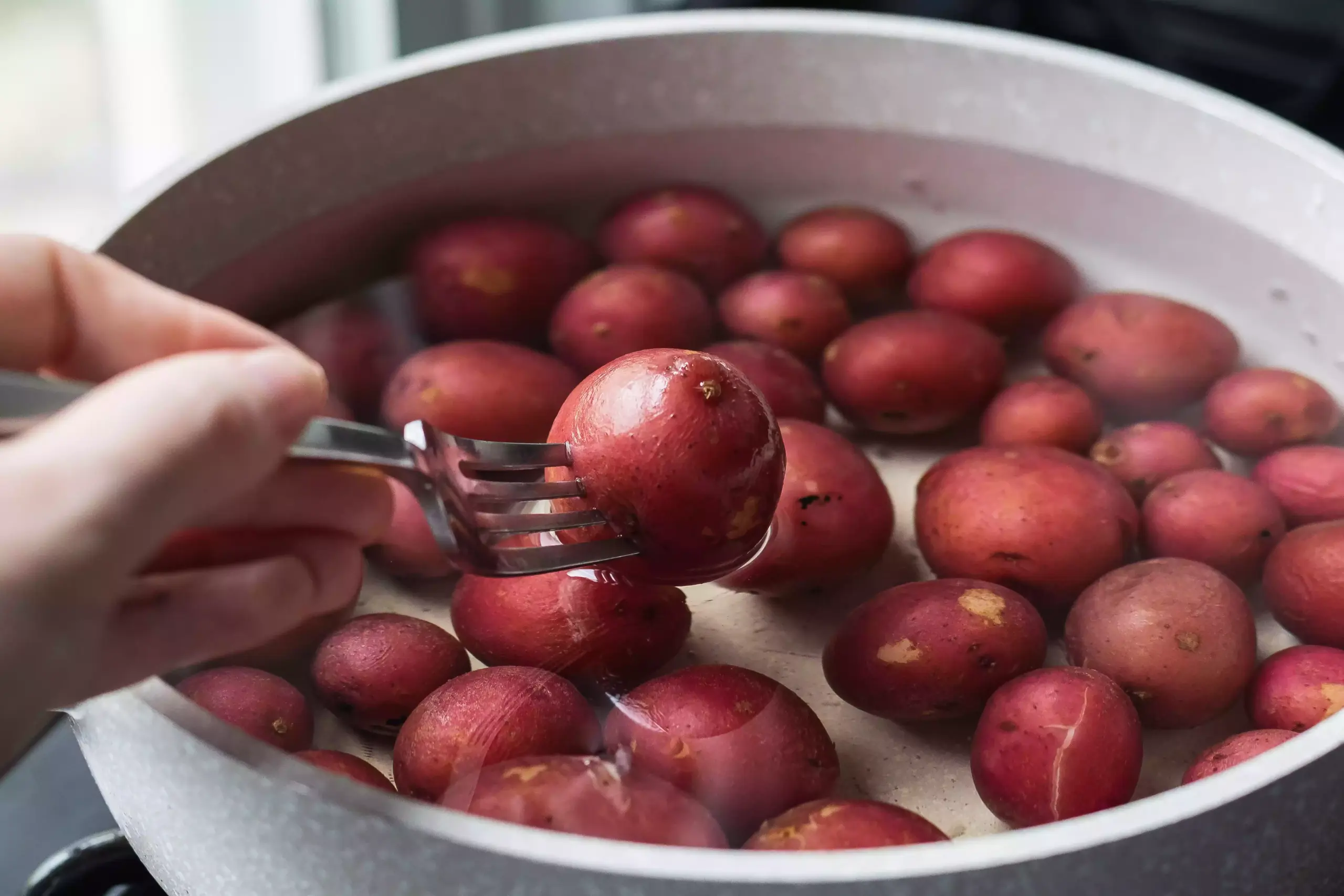 Faire bouillir des pommes de terre rouges pour faire un thon niçois.